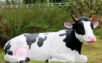 池塘邊一只握著休息的玻璃鋼仿真奶牛雕塑