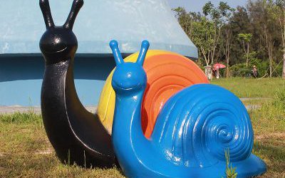 草地上擺放的一黃一藍(lán)兩只玻璃鋼彩繪蝸牛雕塑