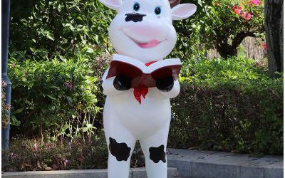 校園擺放一只看書的玻璃鋼卡通奶牛雕塑